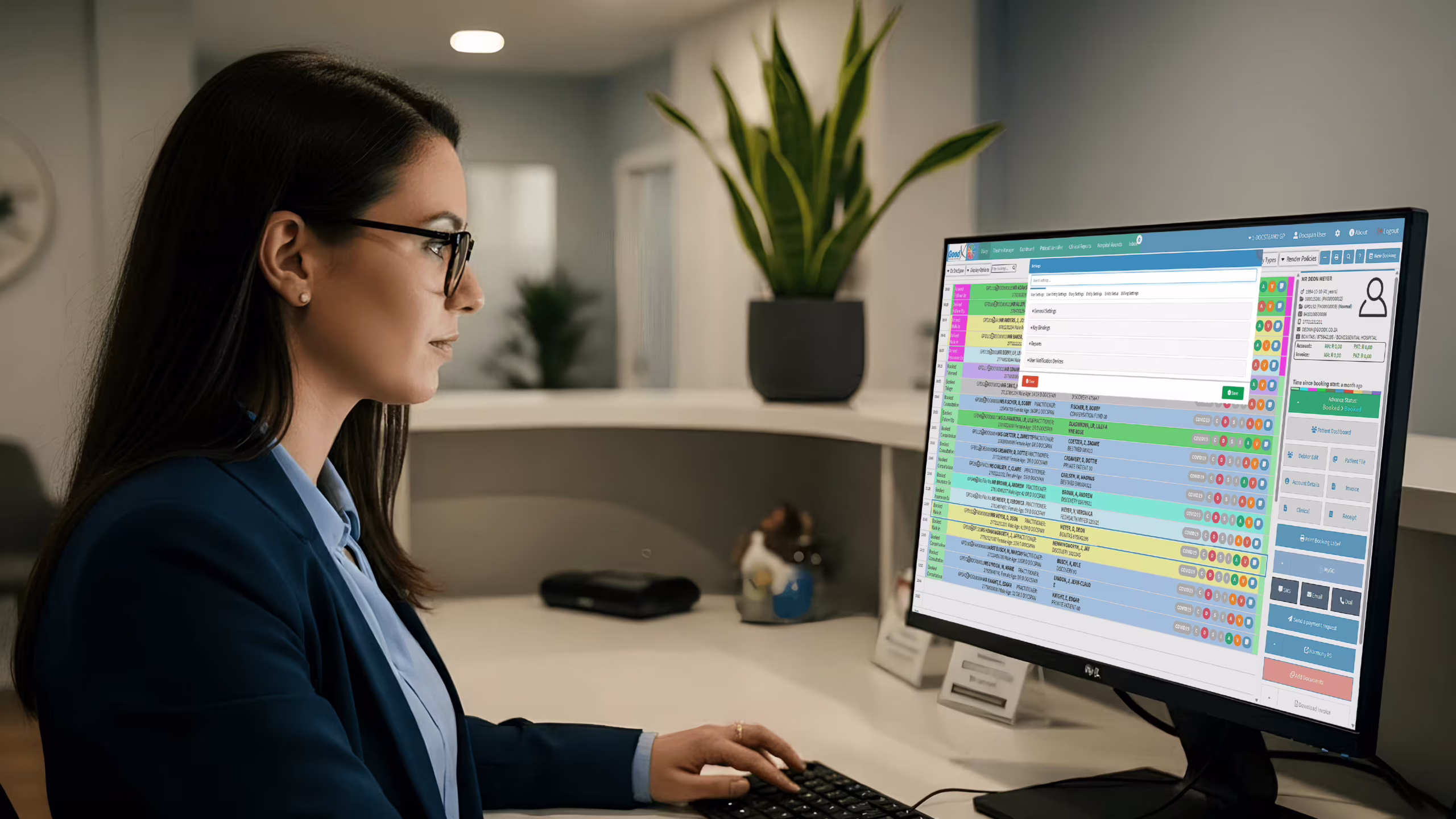 UK dental practice manager using dentist practice management software to review appointments and patient billing at clinic front desk